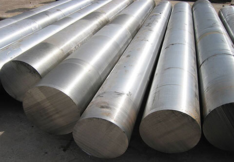 Several large, cylindrical metal rods arranged in parallel lines on a concrete surface.