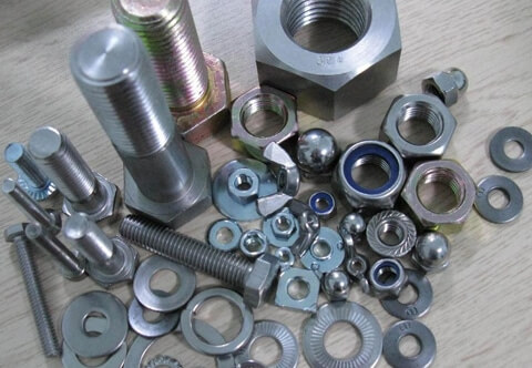 Various nuts and bolts neatly arranged on a table, showcasing a range of sizes and shapes