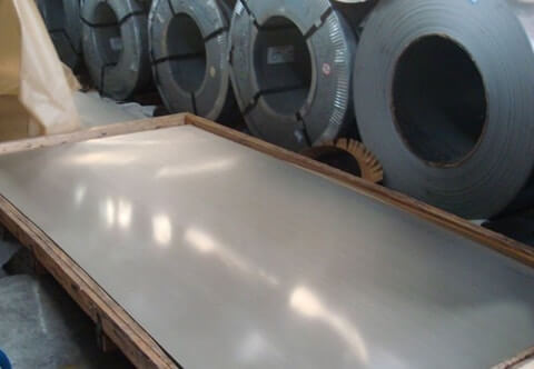 A warehouse with a tall stack of aluminum sheets neatly arranged