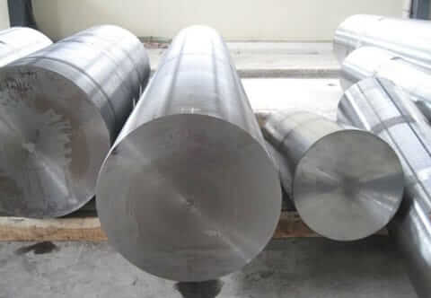 Three large metallic cylindrical rods of varying sizes are placed horizontally on a wooden surface