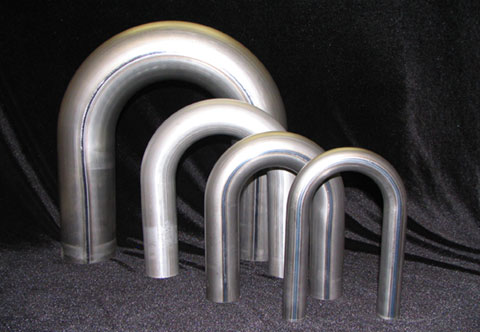 Group of four stainless steel pipes standing upright