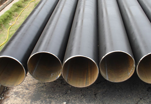 Five large black pipes are shown laid side by side on the ground.